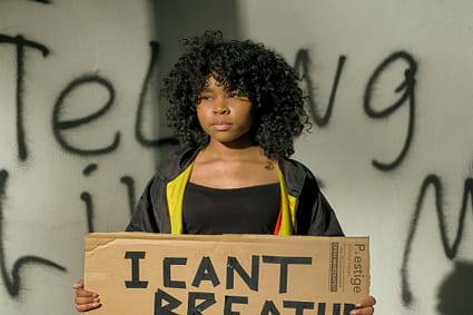 woman in black tank top and gray pants holding brown and white cardboard box