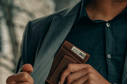 a man holding a wallet and a watch