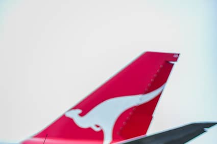 red and white airplane behind a black hatchback