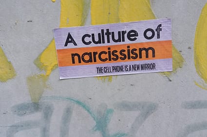 a sign on the side of a wall that says a culture of narciss
