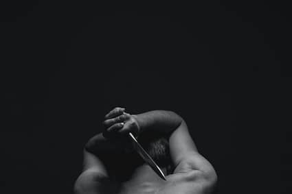 man holding gray dagger
