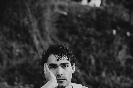 a man sitting on a bench in a field